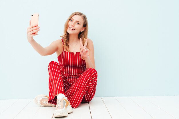 Retrato de joven bella mujer sonriente en ropa de traje rojo de verano de moda