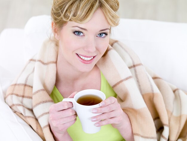 Retrato de joven bella mujer sonriente con taza de café caliente - ángulo alto