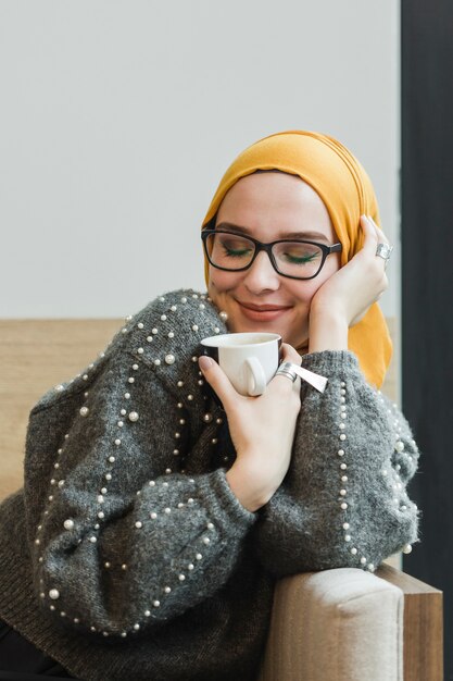 Retrato de joven bella mujer sosteniendo un café