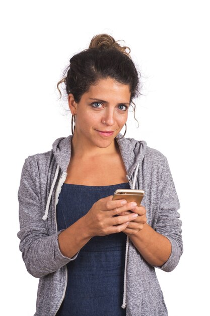 Retrato de joven bella mujer con su teléfono móvil en estudio. Fondo blanco aislado. Concepto de tecnología y comunicación.