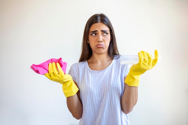 Retrato de una joven cansada con guantes de goma descansando después de limpiar un apartamento concepto de limpieza del hogar