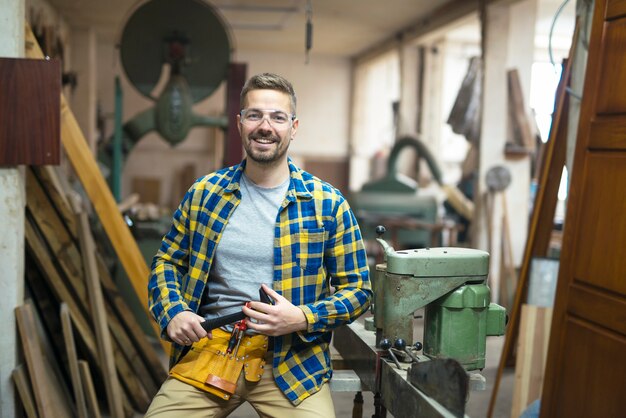 Retrato de joven carpintero en su taller de carpintería