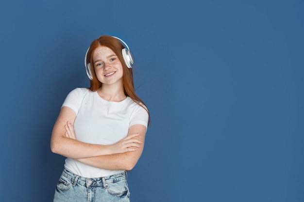 Retrato de la joven caucásica aislado en estudio azul