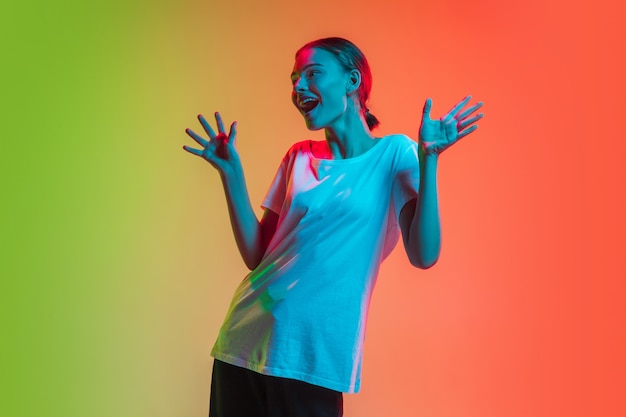 Retrato de joven caucásica en degradado verde-naranja en luz de neón