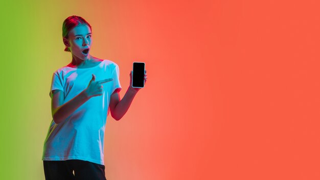 Retrato de joven caucásica en degradado verde-naranja en luz de neón