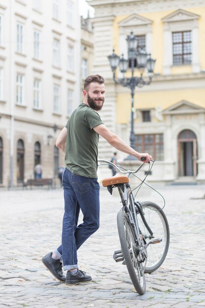Retrato de un joven ciclista masculino con su bicicleta