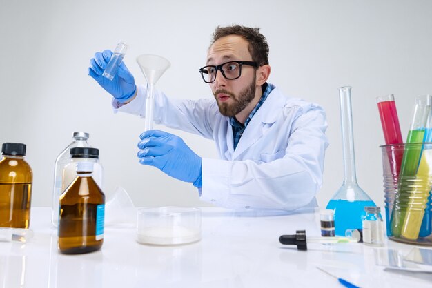 Retrato de joven científico, químico o médico realiza investigaciones químicas en el laboratorio farmacéutico.