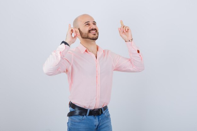 Retrato de un joven confiado apuntando hacia arriba