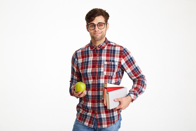 Retrato de un joven confiado estudiante masculino sosteniendo libros