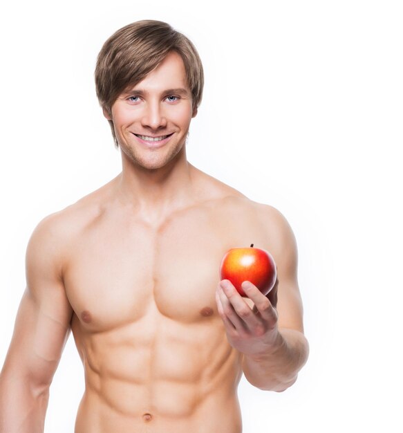 Retrato de joven culturista sonriente sosteniendo apple en su mano