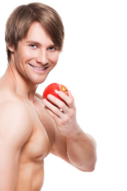 Retrato de joven culturista sonriente sosteniendo apple en su mano