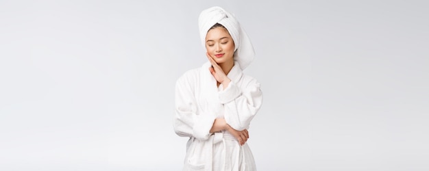 Retrato de una joven dama asiática feliz en albornozAislada en fondo blanco