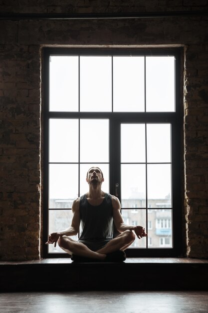 Retrato de un joven deportista concentrado meditando