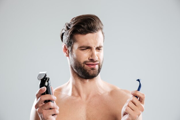 Retrato de un joven dudoso elegir maquinilla de afeitar