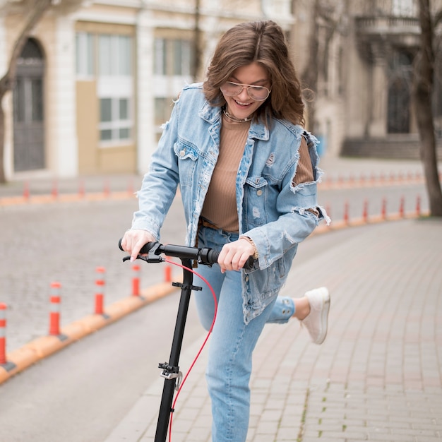 Retrato de joven elegante montando scooter eléctrico