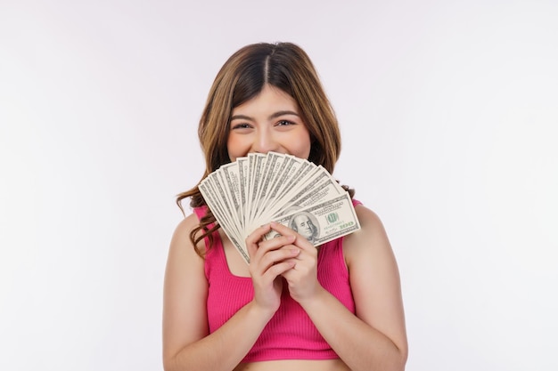 Retrato de una joven emocionada sosteniendo un montón de billetes de dólares aislados sobre fondo blanco