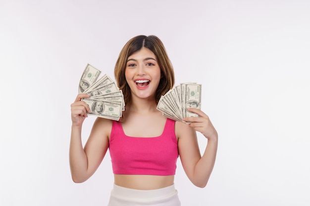 Retrato de una joven emocionada sosteniendo un montón de billetes de dólares aislados sobre fondo blanco