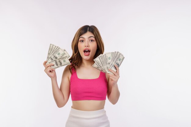 Retrato de una joven emocionada sosteniendo un montón de billetes de dólares aislados sobre fondo blanco