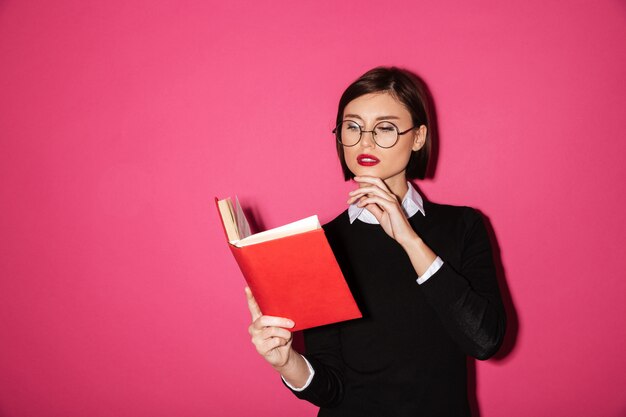 Retrato de una joven empresaria atractiva leyendo un libro