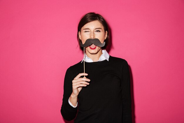 Retrato de una joven empresaria divertida con bigote de papel