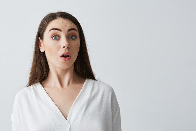 Retrato de joven empresaria hermosa sorprendida con la boca abierta.