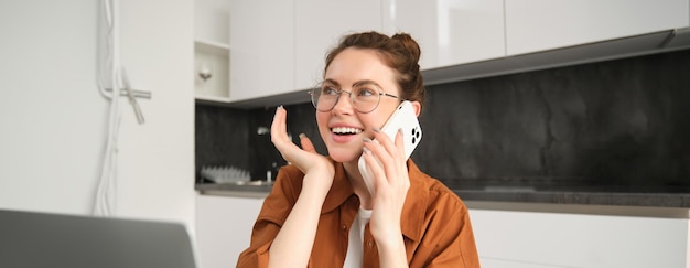 Retrato de una joven empresaria independiente que trabaja desde casa haciendo llamadas telefónicas a los clientes