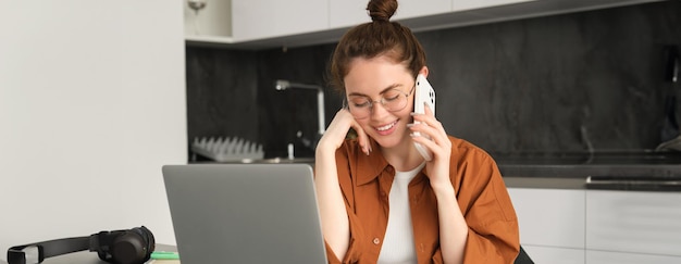 Foto gratuita retrato de una joven empresaria independiente que trabaja desde su casa, una freelancer que llama a una cliente.