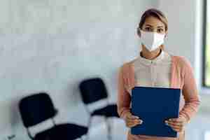 Foto gratuita retrato de joven empresaria con mascarilla esperando una entrevista de trabajo