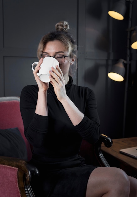 Foto gratuita retrato de joven empresaria tomando café