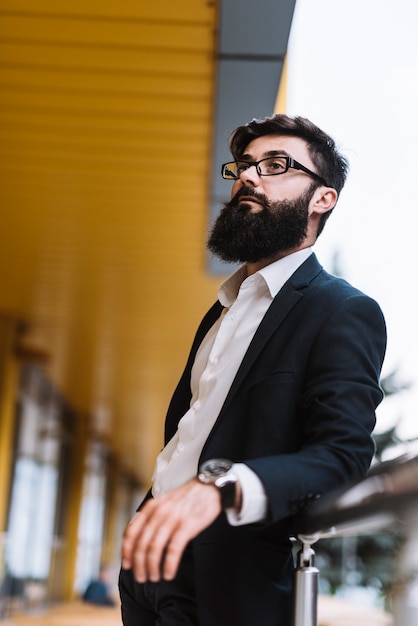Foto gratuita retrato de joven empresario barbudo con anteojos negros