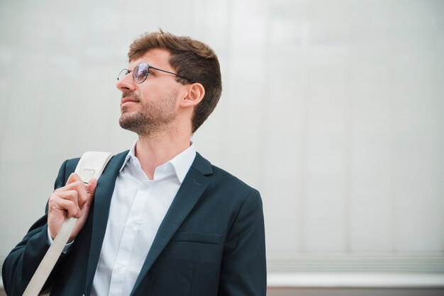 Retrato de un joven empresario con bolsa en su hombro