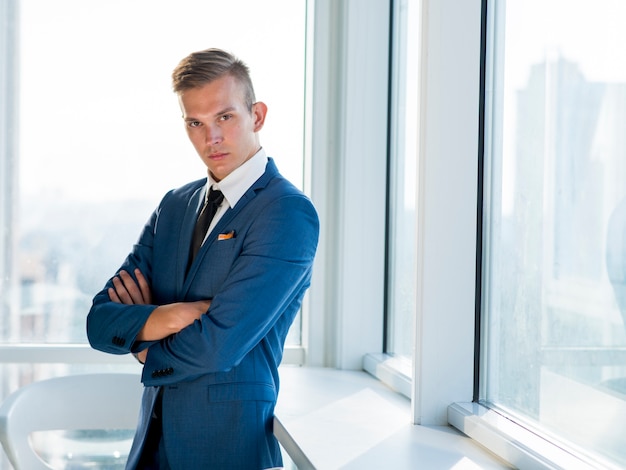 Foto gratuita retrato de un joven empresario con los brazos cruzados