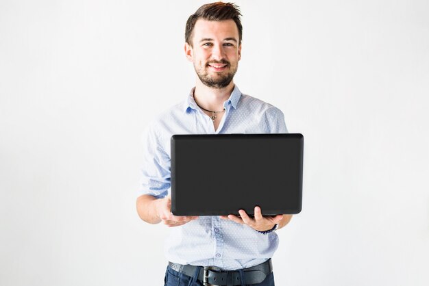 Retrato de un joven empresario feliz usando laptop