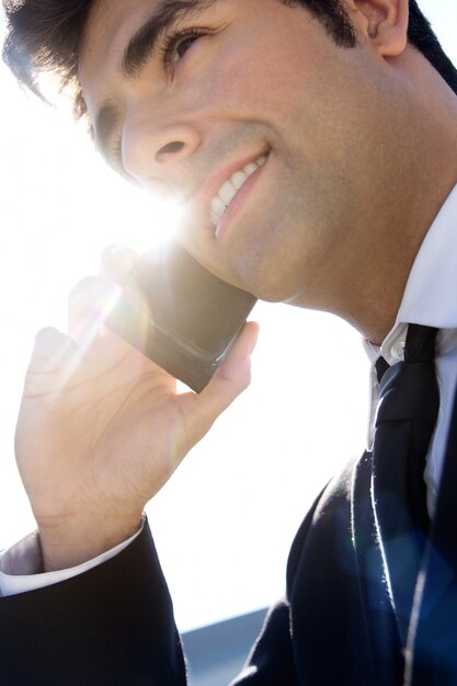 Retrato de joven empresario hablando con smartphone