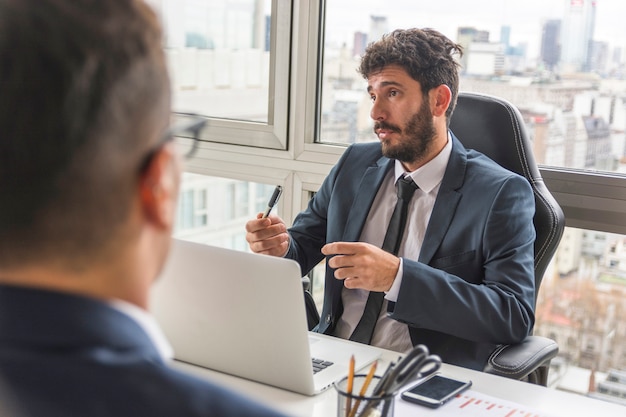 Retrato de joven empresario hablando con su colega