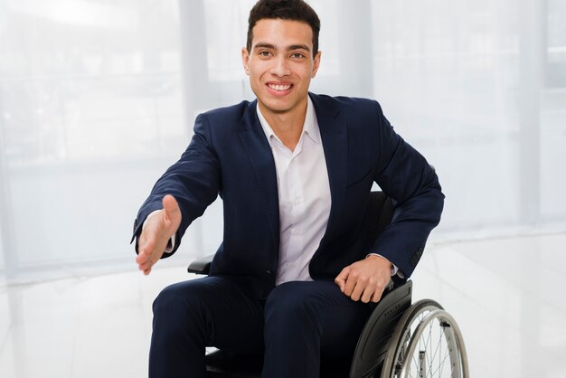 Retrato de un joven empresario sonriente se acerca a la cámara para darle la mano