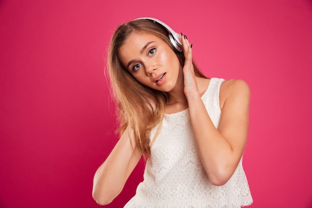 Retrato de una joven escuchando música con auriculares