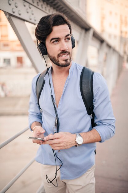 Retrato de un joven escuchando música en auriculares