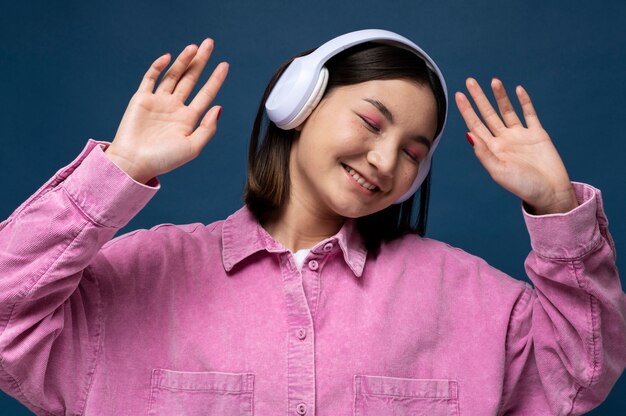 Retrato de una joven escuchando música y bailando