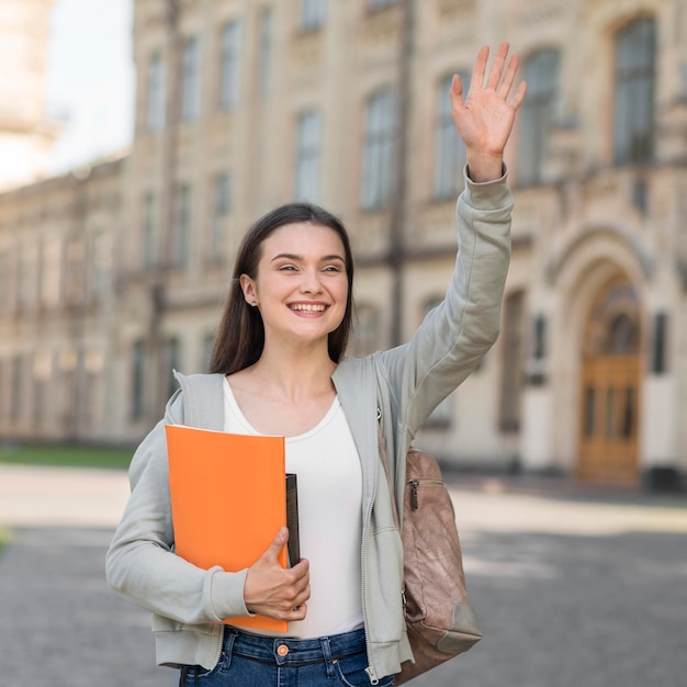 Foto gratuita retrato de joven estudiante feliz de volver a la universidad