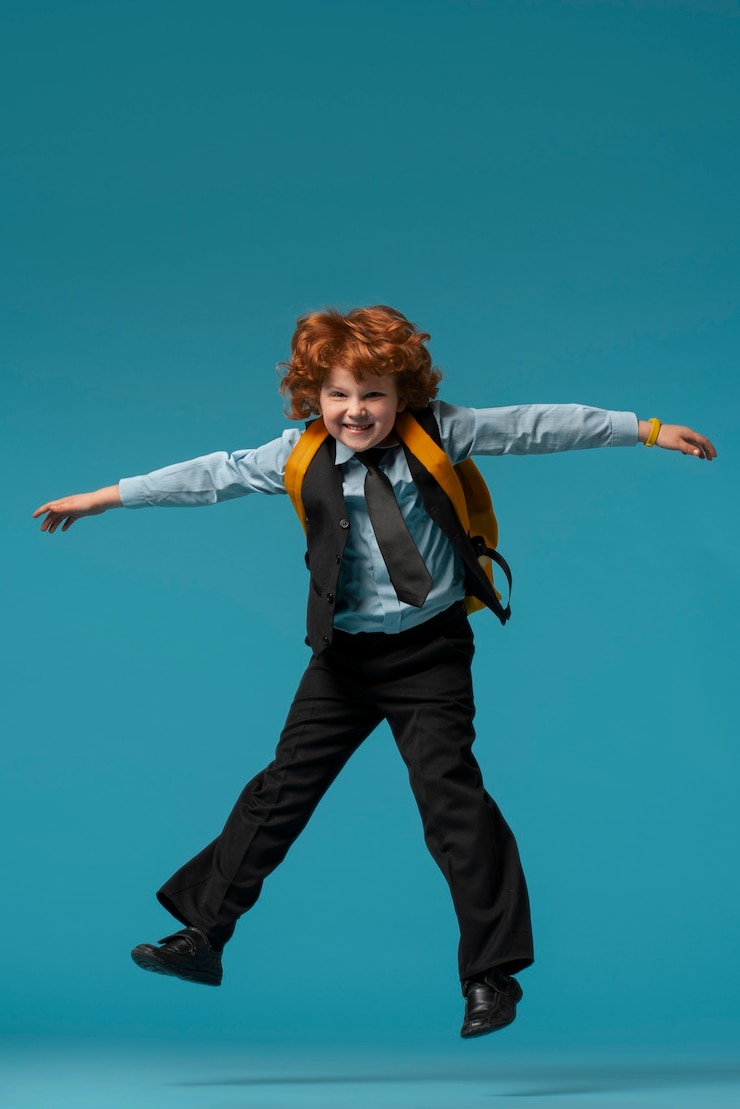 Foto gratuito retrato de joven estudiante en uniforme escolar saltando en el aire