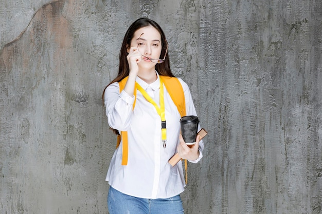 Retrato de joven estudiante en vasos sosteniendo una taza de café. foto de alta calidad