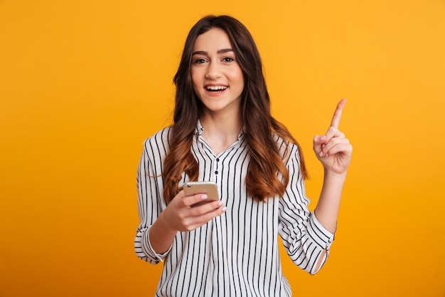 Retrato de una joven excitada con teléfono móvil