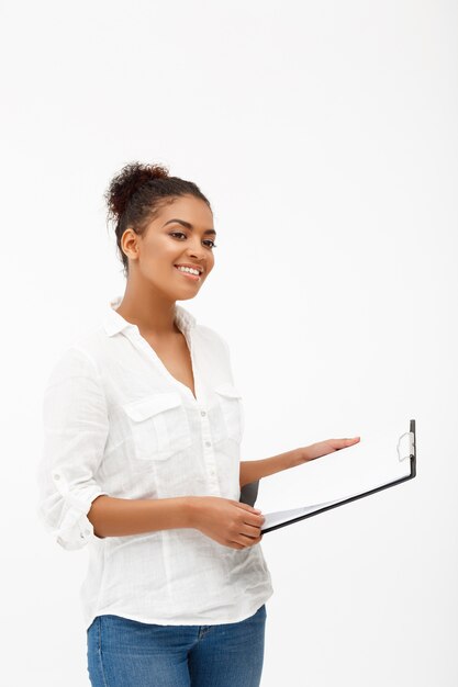 Retrato de joven exitosa mujer de negocios africanos sobre pared blanca