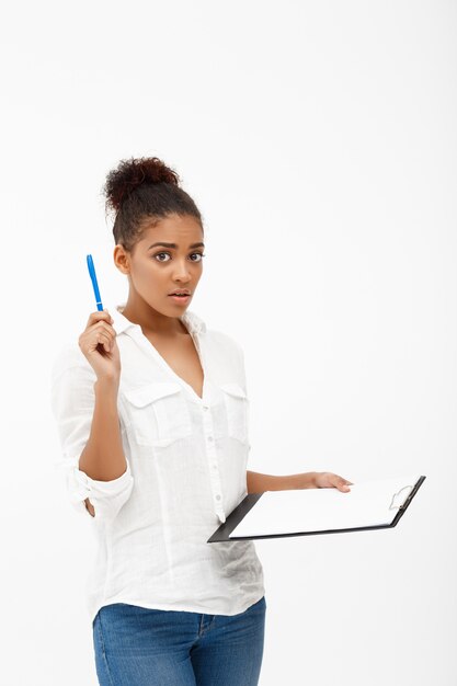 Retrato de joven exitosa mujer de negocios africanos sobre pared blanca