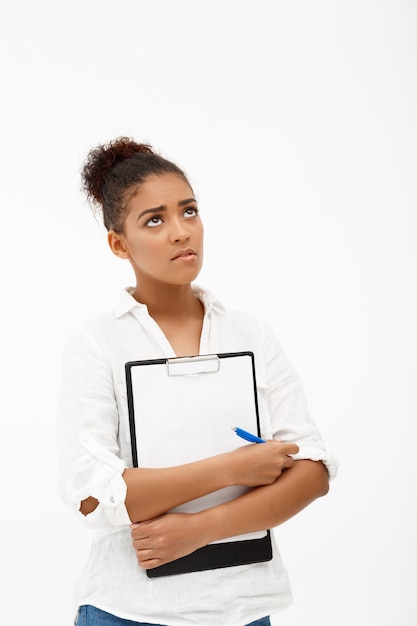 Retrato de joven exitosa mujer de negocios africanos sobre pared blanca