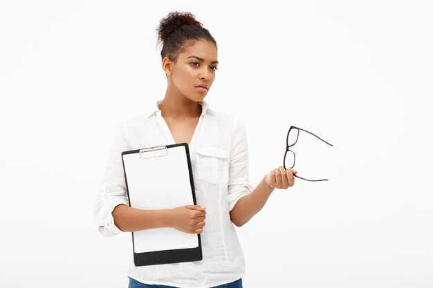 Retrato de joven exitosa mujer de negocios africanos sobre pared blanca