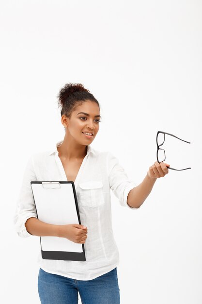 Retrato de joven exitosa mujer de negocios africanos sobre pared blanca