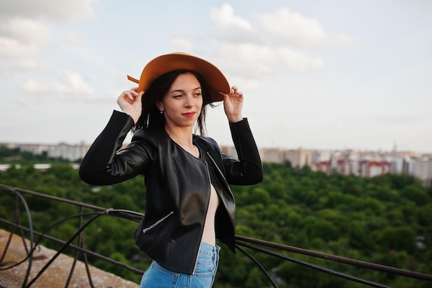 Retrato de una joven fabulosa con ropa informal posando con un sombrero naranja