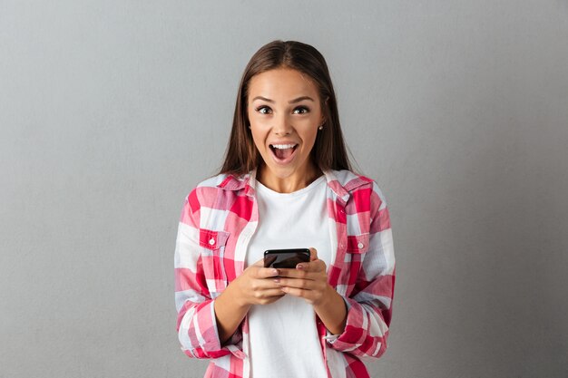 Retrato de joven feliz, mensaje de texto en los teléfonos